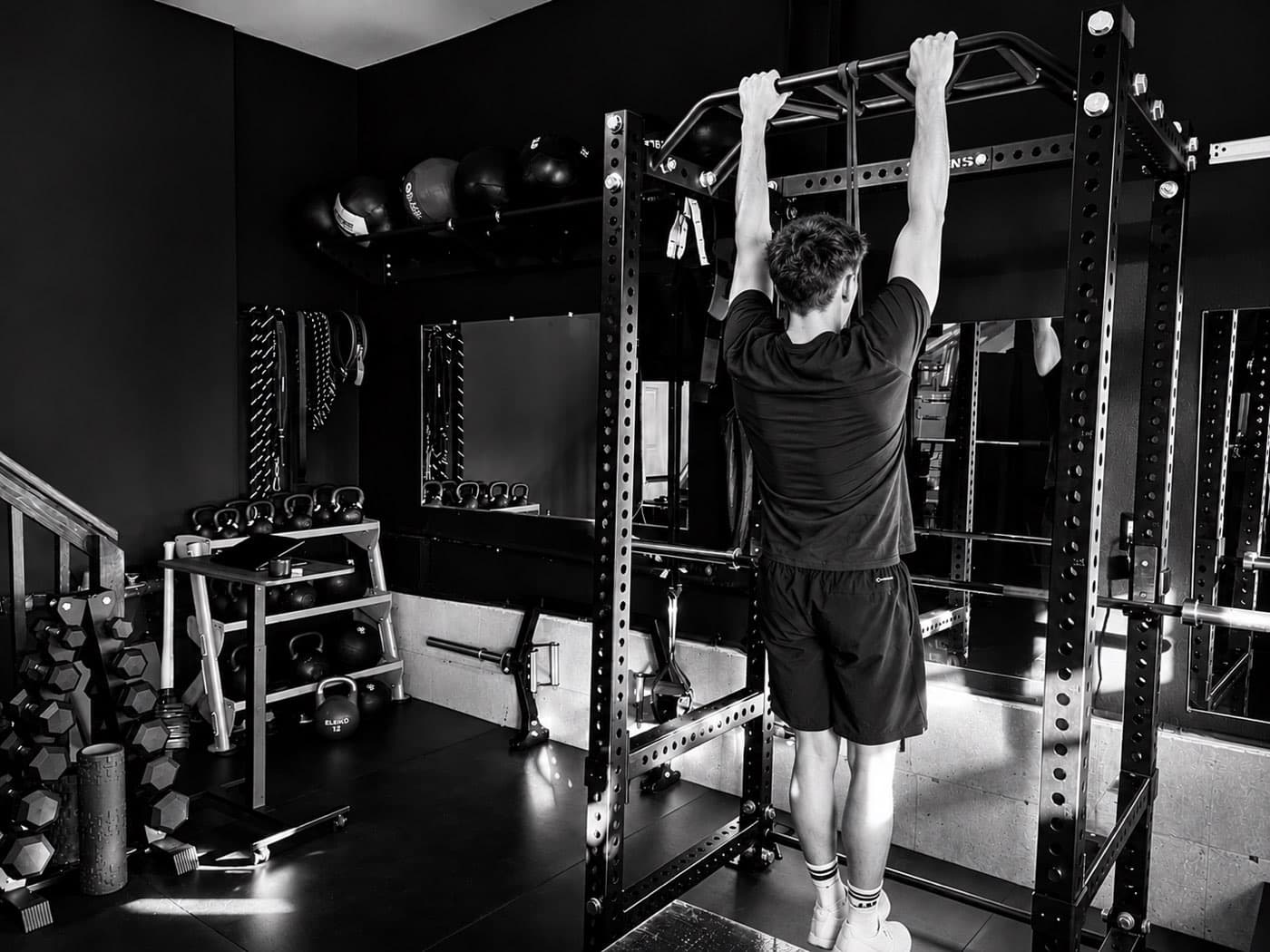 Adult doing pull-ups during a strength training session