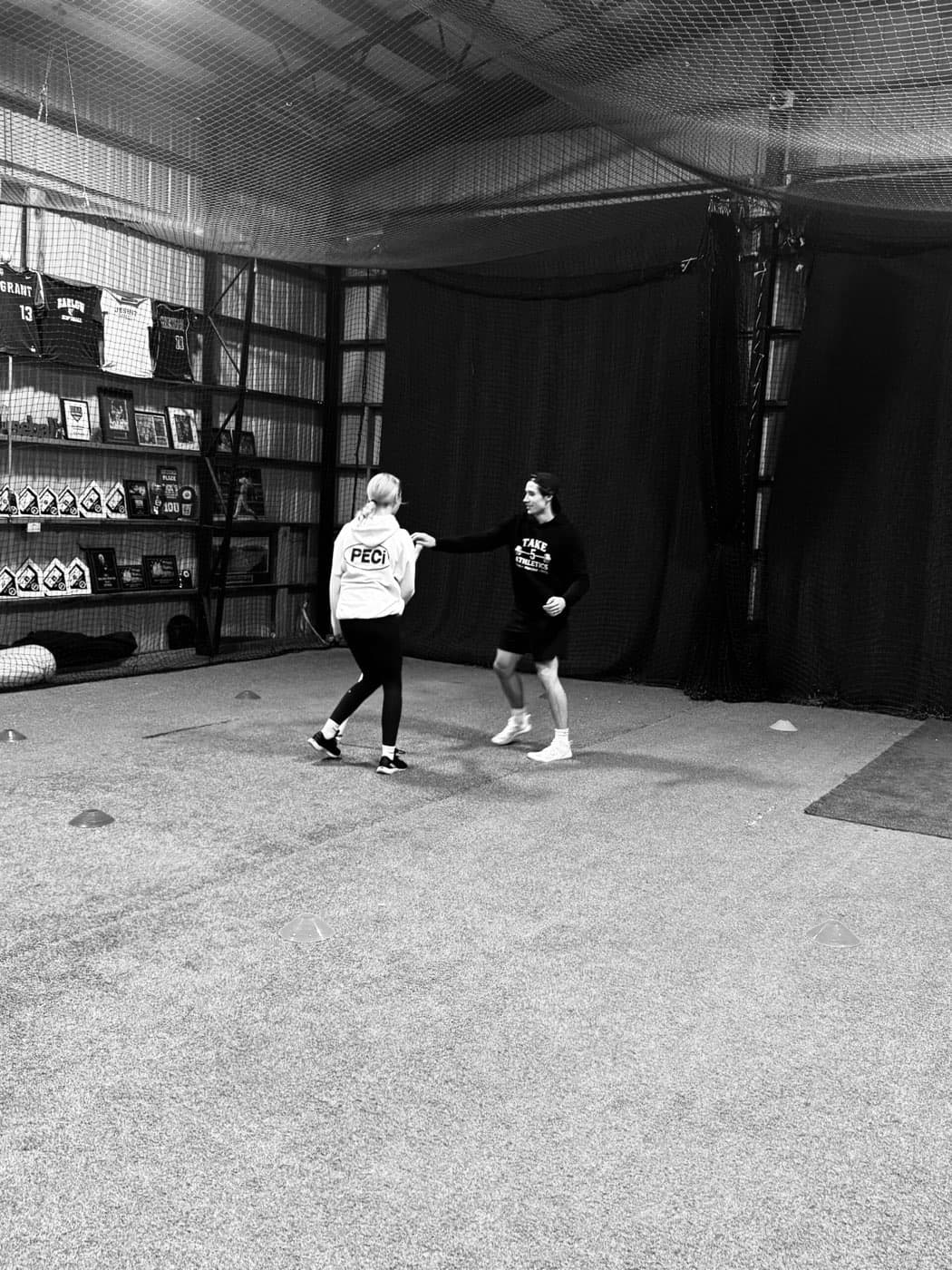 Coach working one-on-one with a youth athlete on movement